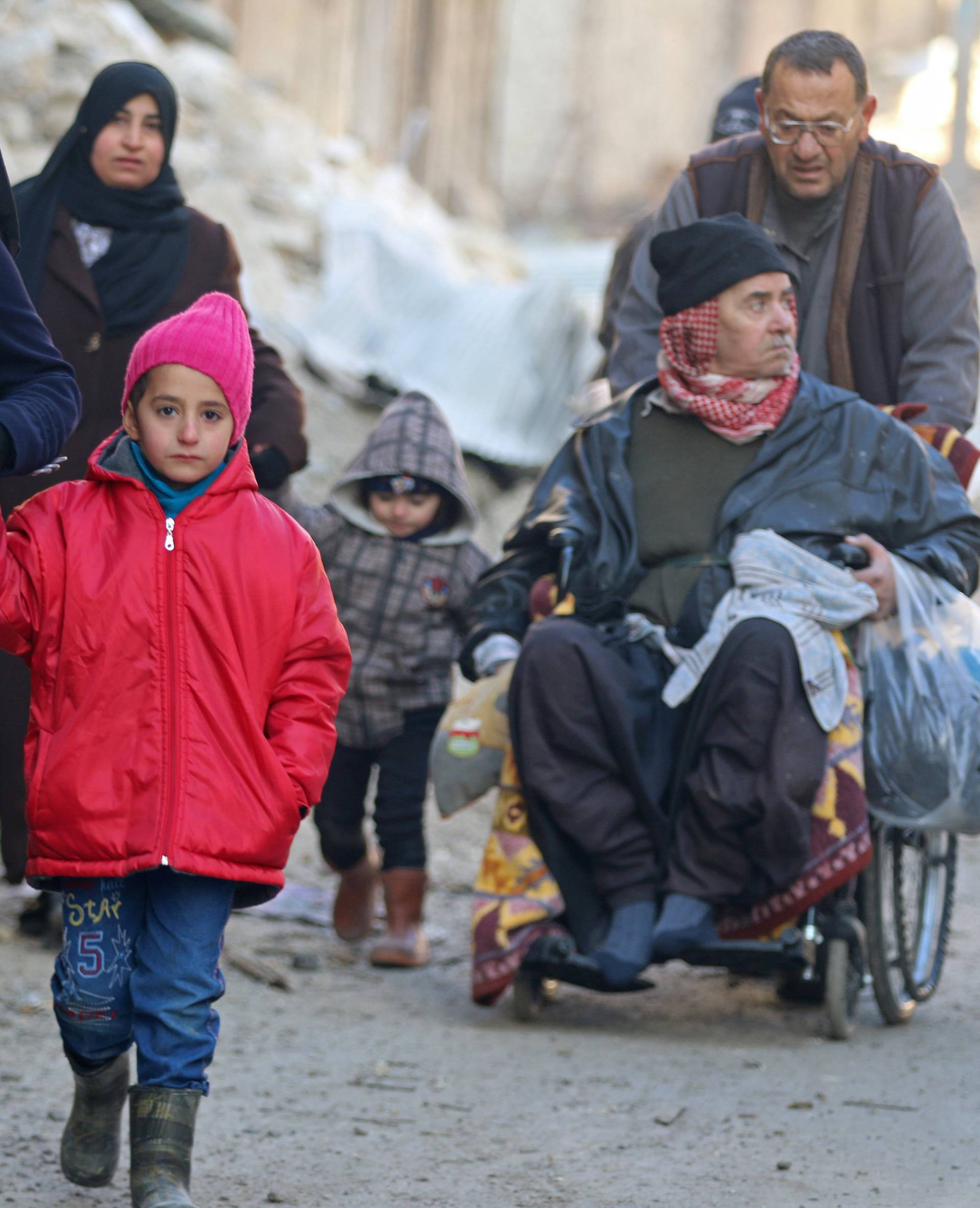 People walk as they gather to be evacuated from a rebel-held sector of eastern Aleppo