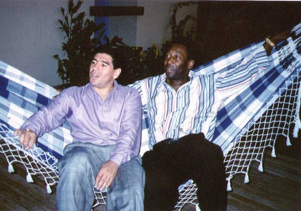 FILE PHOTO: Soccer legends Diego Maradona and Pele rest on a hammock during a reception in Rio de Janeiro