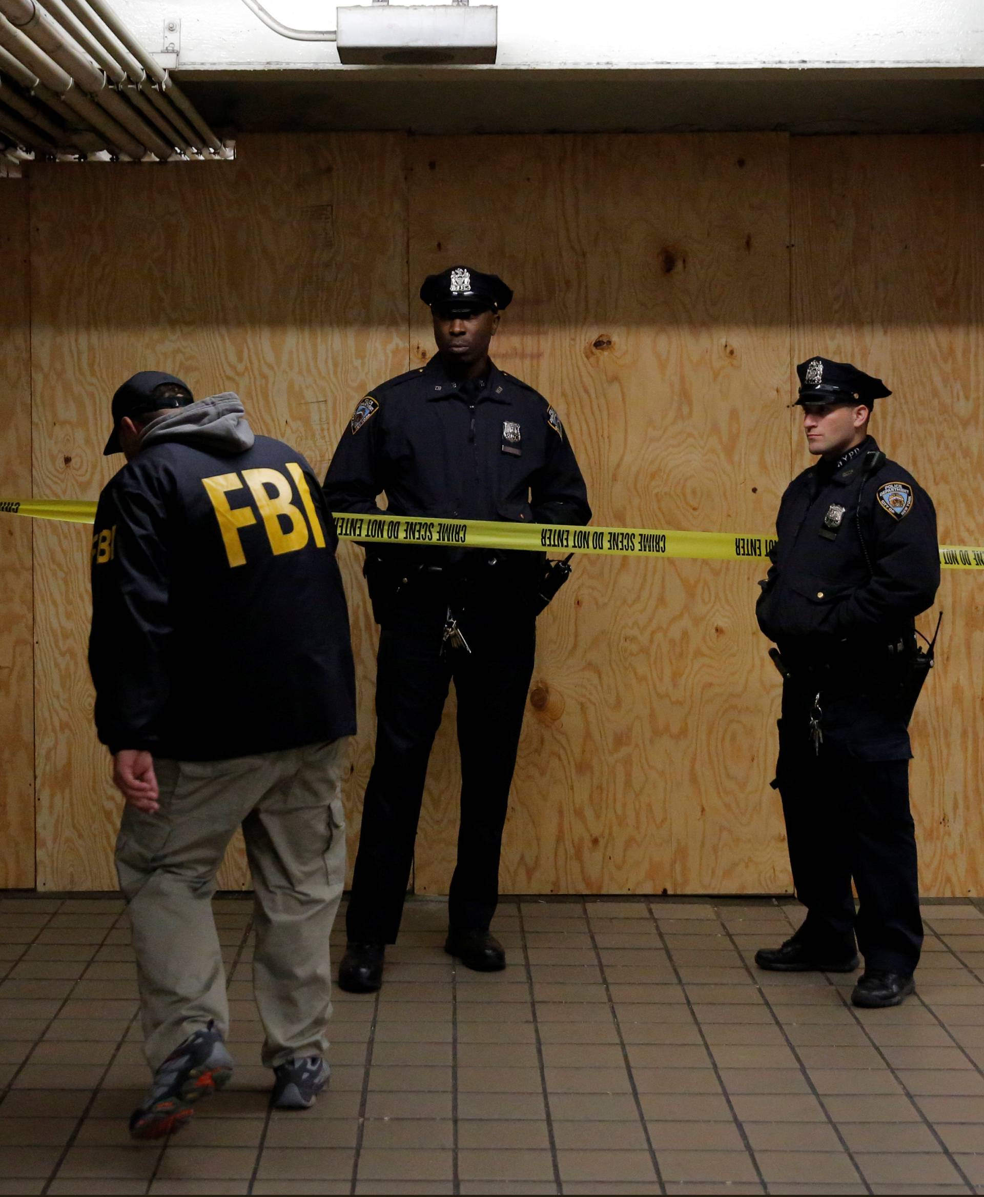 A member of the FBI enters the crime scene beneath the New York Port Authority Bus Terminal following an attempted detonation during the morning rush hour, in New York City