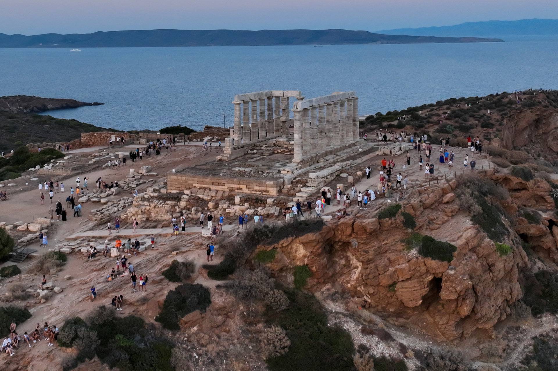 People visit the Temple of Poseidon, in Cape Sounion, near Athen