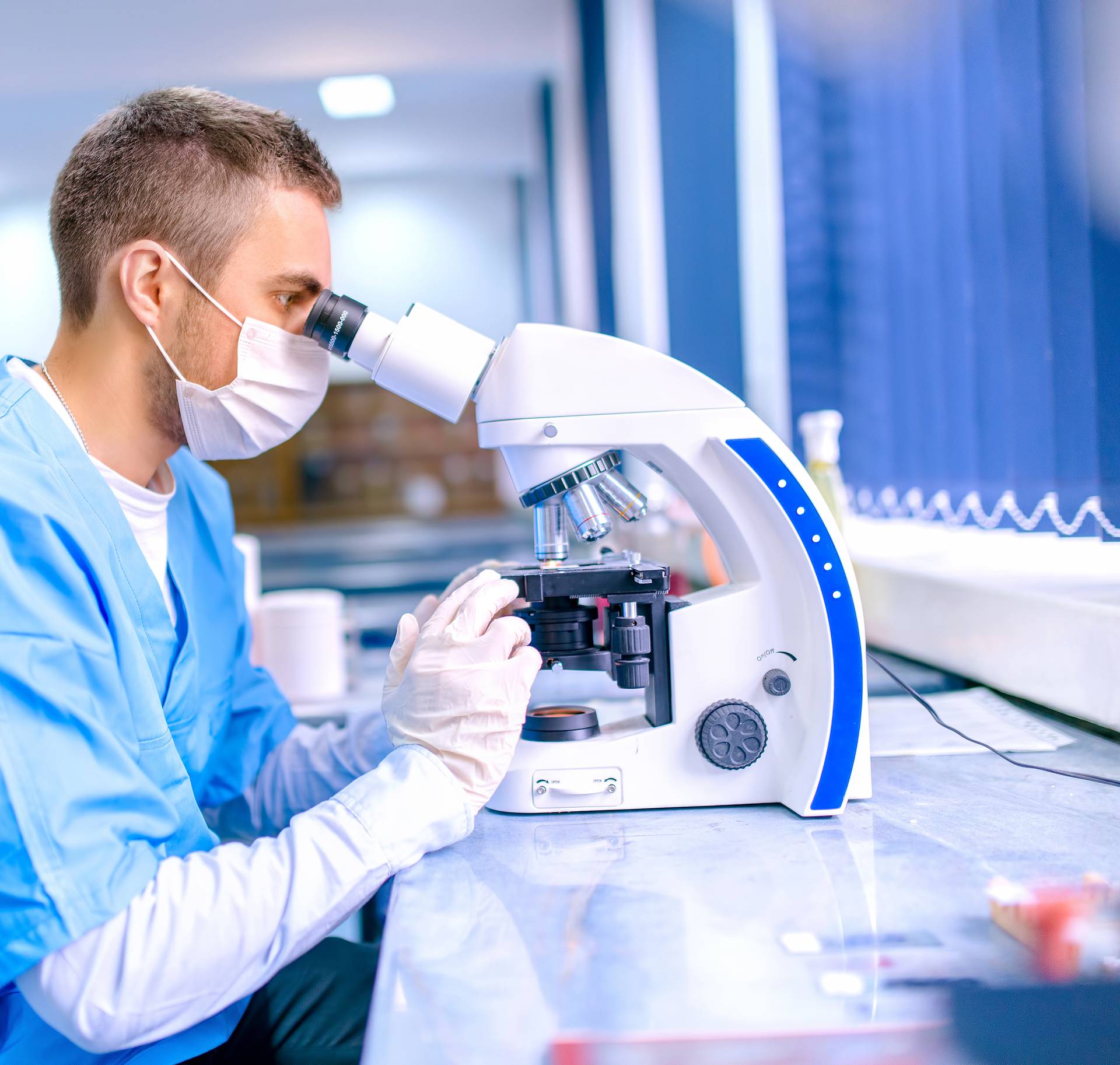 Male scientist, chemist working with microscope in pharmaceutica