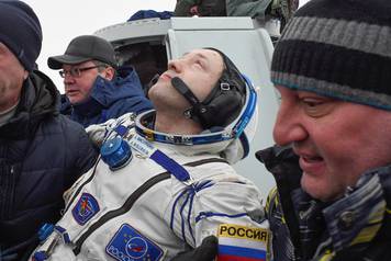 Ground personnel carry Alexander Misurkin of Russia after the Soyuz MS-06 capsule landed in a remote area outside the town of Dzhezkazgan (Zhezkazgan), Kazakhstan