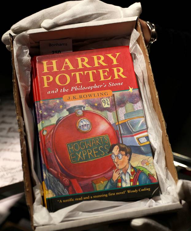 One of the first ever copies of "Harry Potter and the Philosopher's Stone" by J.K. Rowling, is held by a staff member at Bonhams auctioneers, ahead the Fine Books, Manuscripts, Atlases and Historical Photographs sale in London