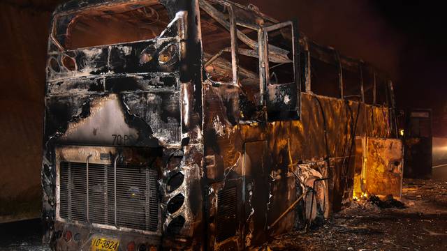 Firefighters extinguish a fire on board a bus in Tak province