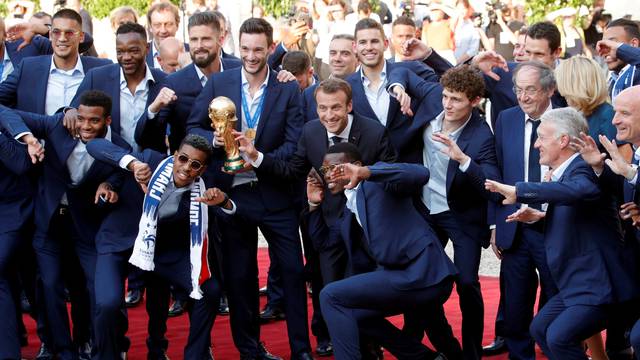 French President Emmanuel Macron and his wife Brigitte Macron pose with France soccer team captain Hugo Lloris holding the trophy, coach Didier Deschamps and players before a reception to honour the France soccer team at the Elysee Palace in Paris
