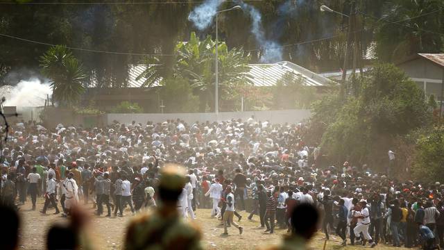 Protestors run from tear gas launched by security personnel during the Irecha, the thanks giving festival of the Oromo people in Bishoftu town of Oromia region, Ethiopia