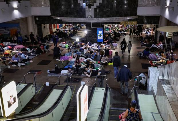 People take shelter inside a metro station during a Russian drone and missile strike in Kyiv