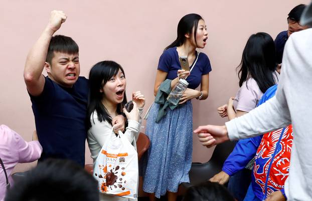 Supporters of local candidate Kelvin Lam celebrate at a polling station in the South Horizons West district in Hong Kong