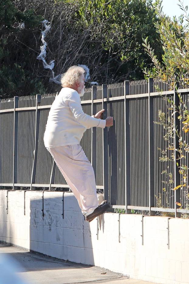 *EXCLUSIVE* Nick Nolte climbs a fence in his PJ