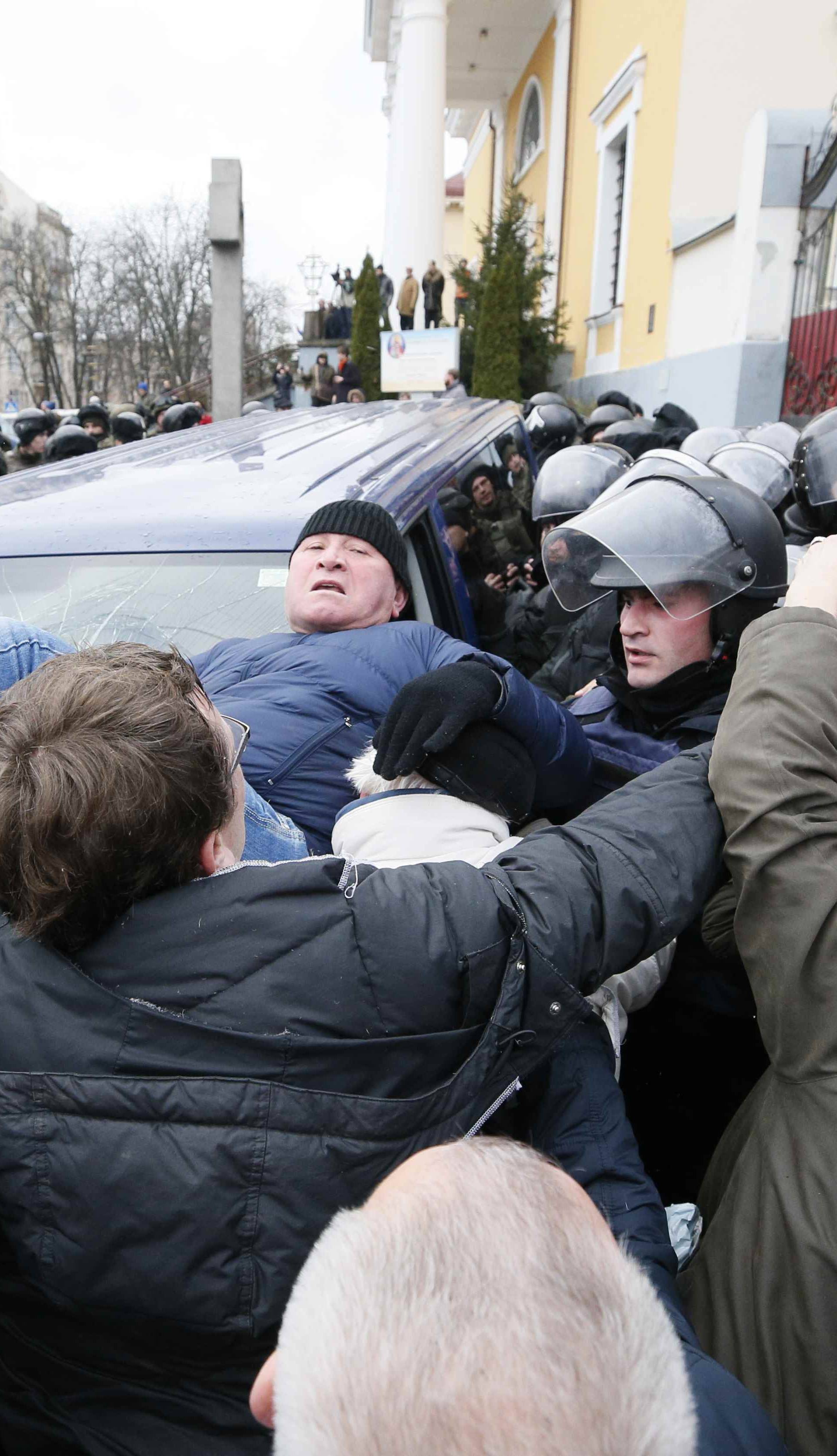 Supporters of Georgian former President Mikheil Saakashvili clash with police officers guarding a car carrying Saakashvili onboard, in Kiev