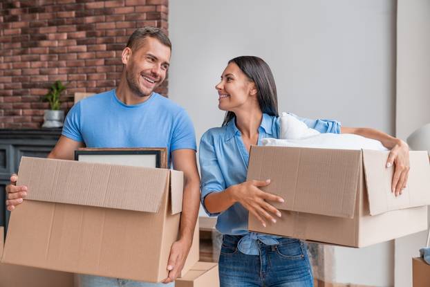 Young,Family,Holding,Cartoon,Boxes,While,Moving,To,New,Home.