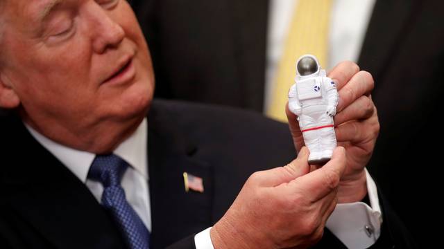 U.S. President Donald Trump holds a space astronaut toy as he participates in a signing ceremony for Space Policy Directive at the White House in Washington D.C.