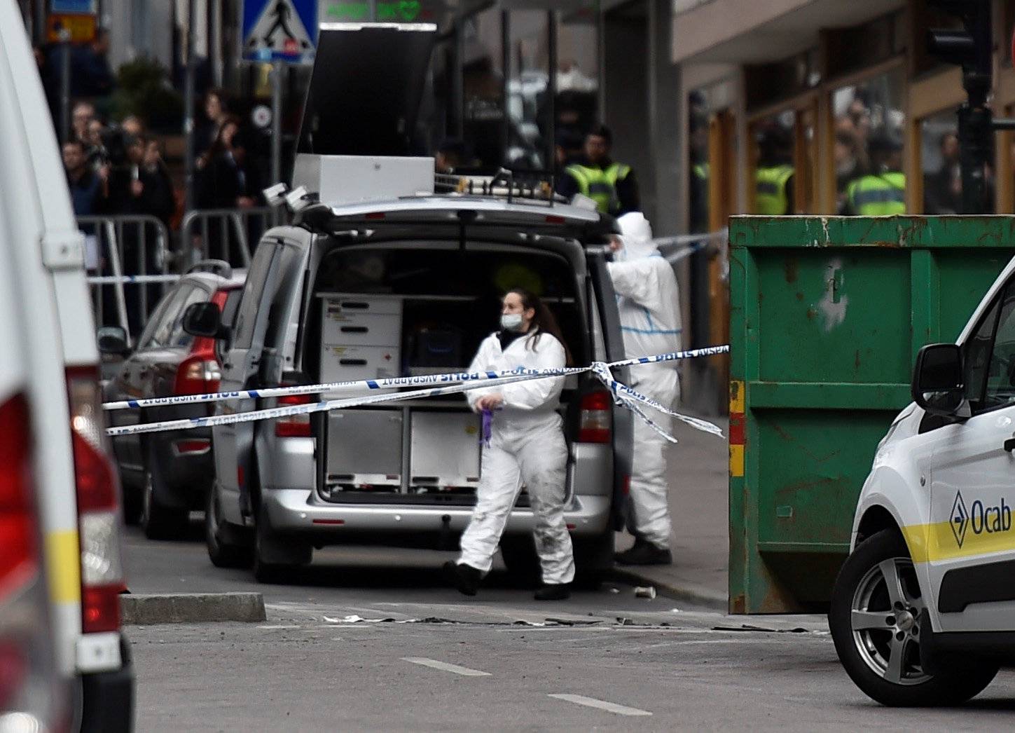 Forensic police investigators work at the crime scene in central Stockholm