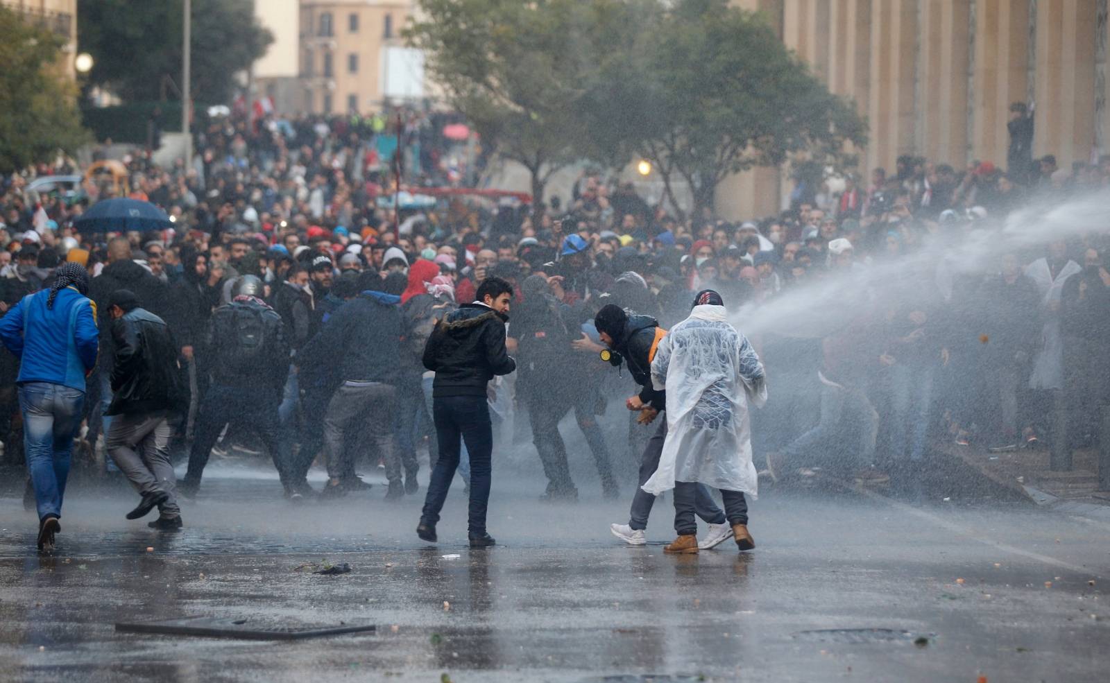 Demonstrators are hit by water canon during a protest against a ruling elite accused of steering Lebanon towards economic crisis in Beirut
