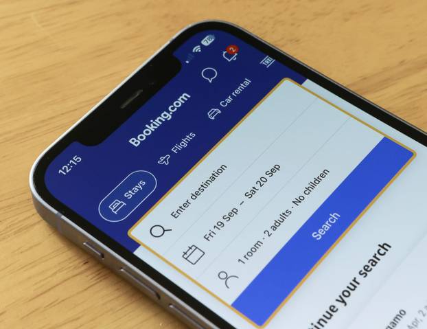 BOOKING.COM HOTEL APP, travel apps, and websites on an iPhone 12 smartphone screen