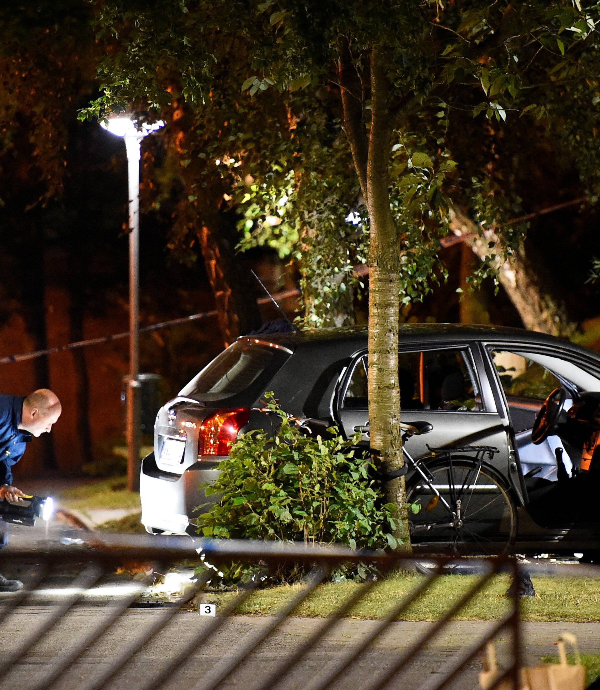 Police technicians examine the car which people who were injured were traveling in, after a shooting in southern Malmo
