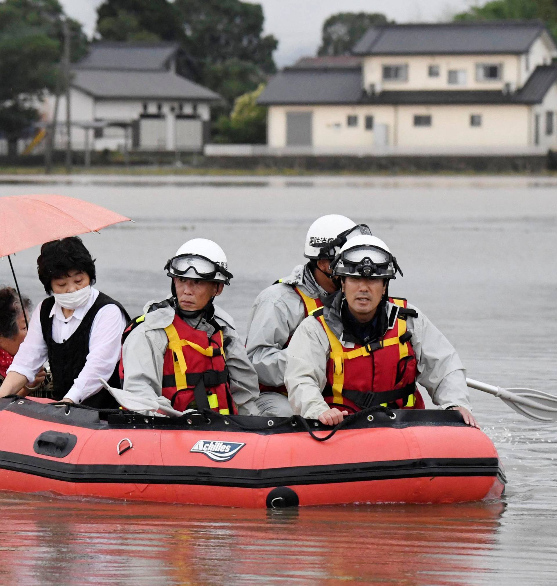 Local residents are rescued by firefighters after heavy rain hit the area in Asakura