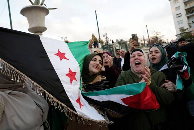 Syrians living in Greece gather after Syrian rebels announced that they have ousted President Bashar al-Assad in Syria, in Athens