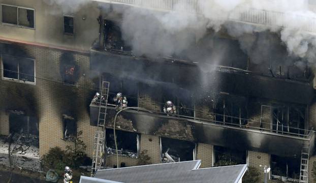 An aerial view shows firefighters battling the fires at the site where a man started a fire after spraying a liquid, at a three-story studio of Kyoto Animation Co. in Kyoto, western Japan, in this photo taken by Kyodo