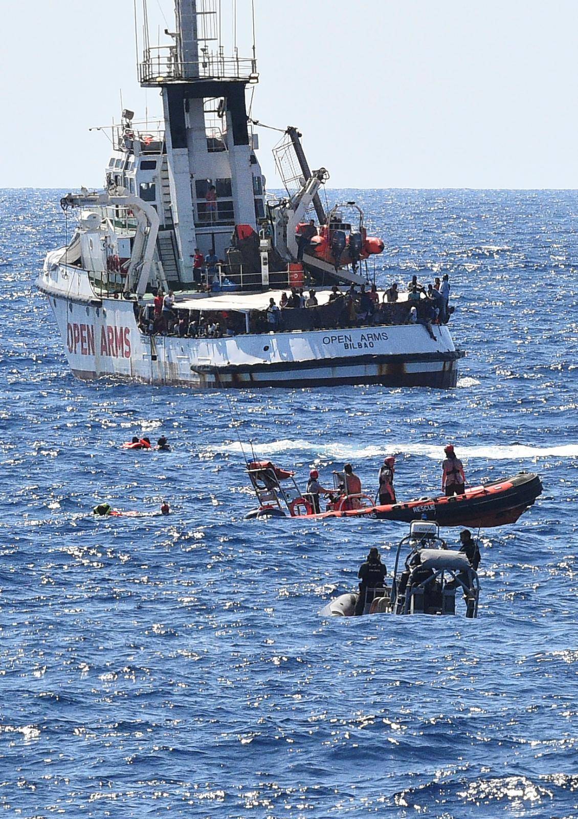 Migrants jump off the Spanish rescue ship Open Arms, close to the Italian shore in Lampedusa