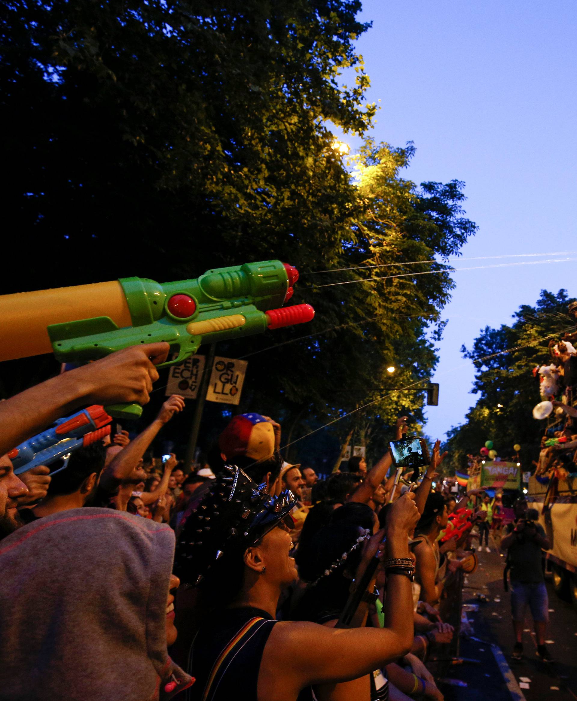 Participants squirt water while attending the World Pride parade in Madrid
