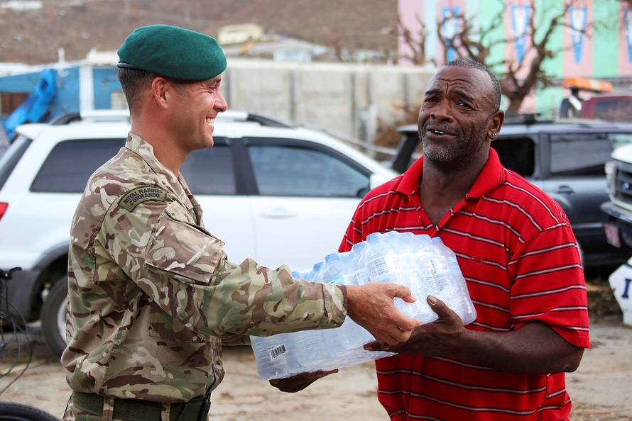 A Royal Marine Commando hands out aid in Tortola in the British Virgin Islands