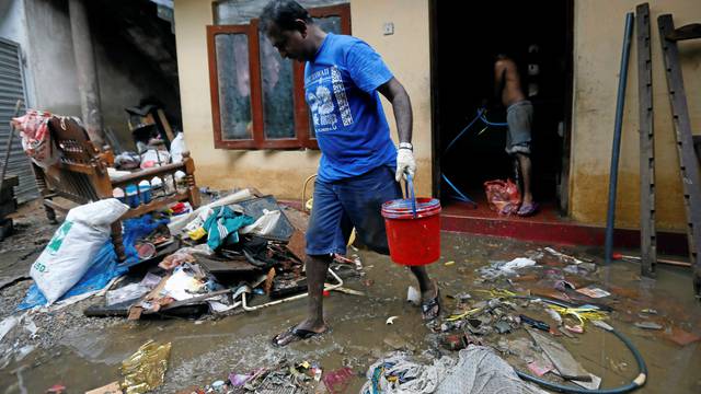 A man cleans his house which was affected by the floods in Biyagama, Sri Lanka