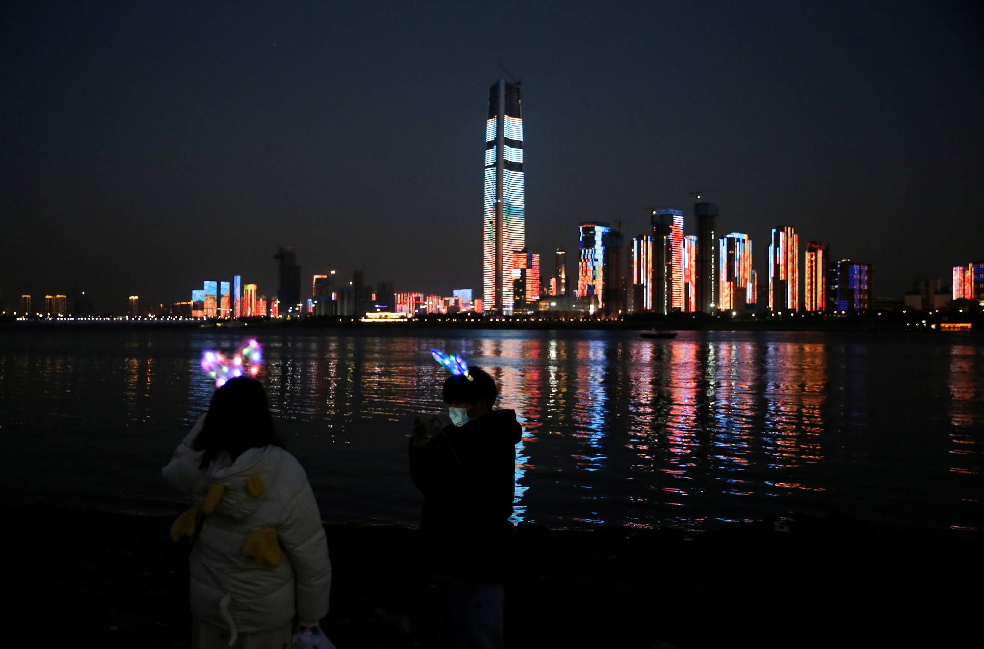 Light show is projected on buildings by a river on New Year's Eve in Wuhan