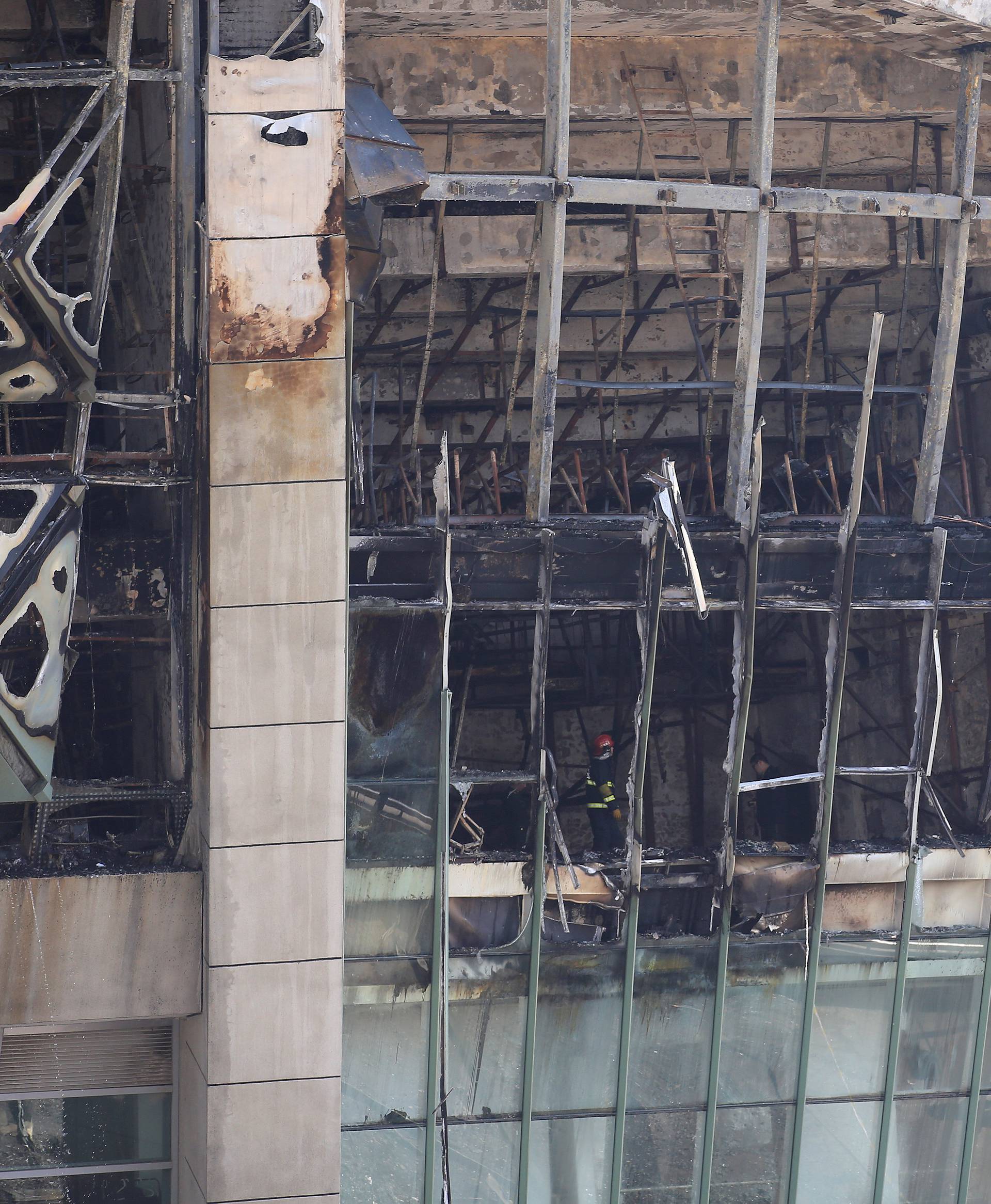 Firefighters inspect the site where a fire broke out at the Shanghai Hongkou soccer stadium in Shanghai,