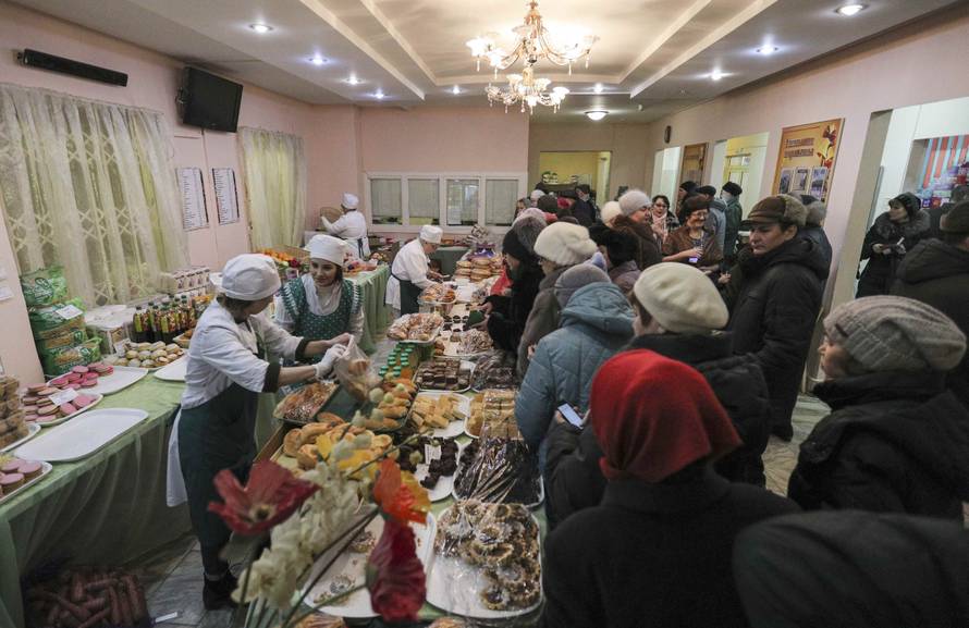 People queue before buying snacks at a polling station during the presidential election in Kazan