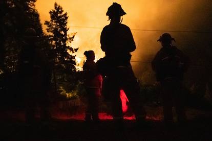 Santa Rosa firefighters monitor the LNU Lightning Complex Fire from a neighboring hilltop in Healdsburg, California