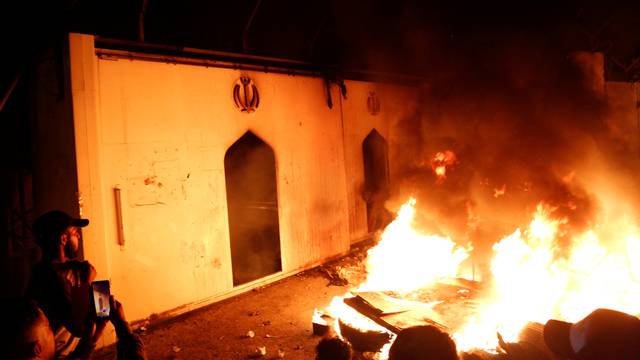 Demonstrators set fire in front of the Iranian consulate, as they gather during ongoing anti-government protests in Najaf