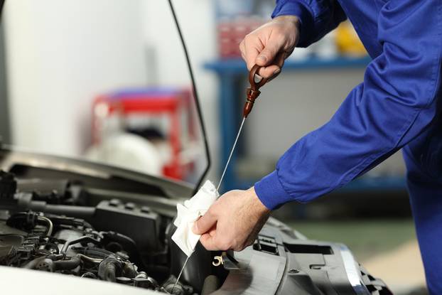 Close,Up,Of,A,Car,Mechanic,Checking,Oil,Level,In