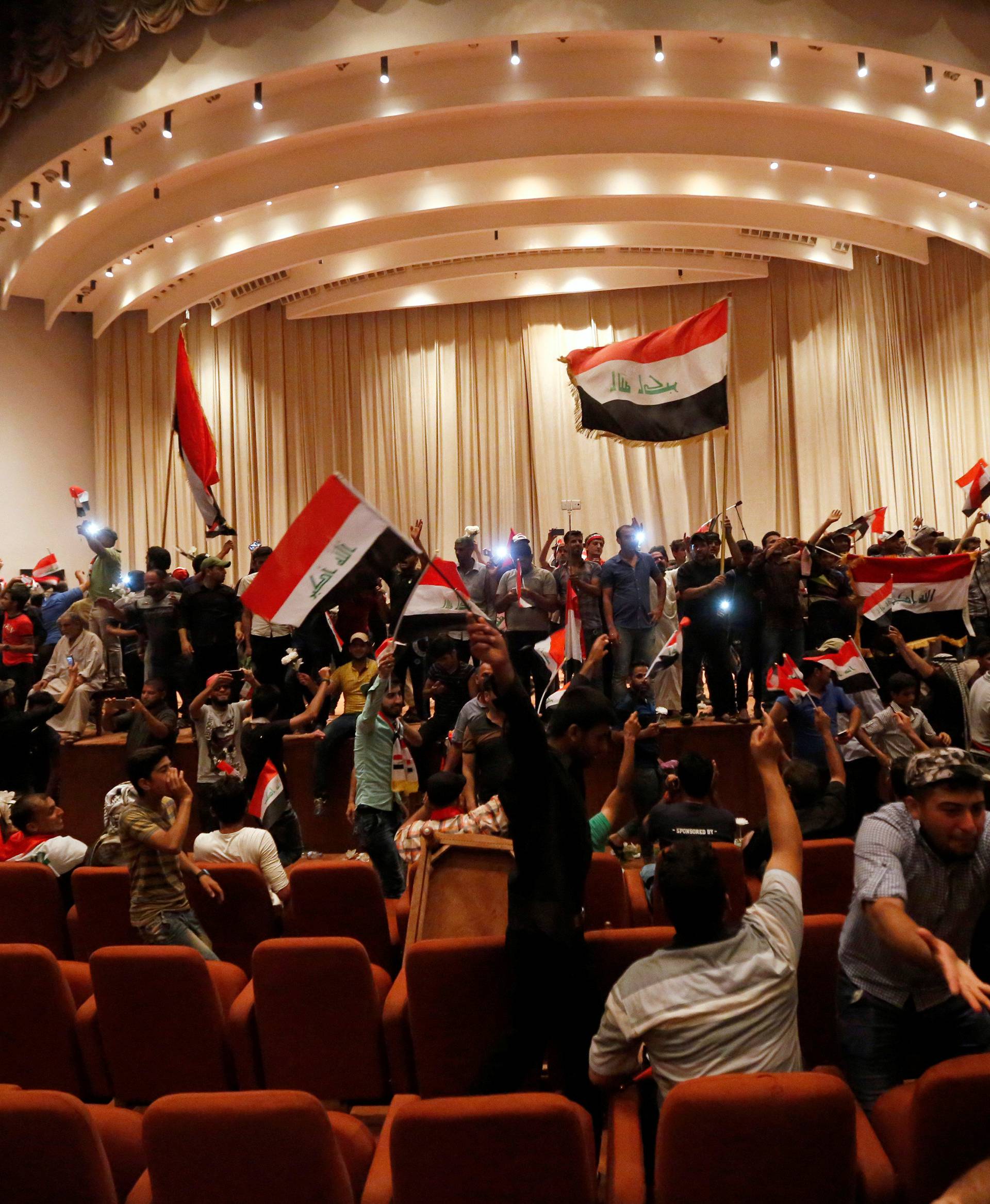 Followers of Iraq's Shi'ite cleric Moqtada al-Sadr are seen in the parliament building as they storm Baghdad's Green Zone after lawmakers failed to convene for a vote on overhauling the government, in Iraq