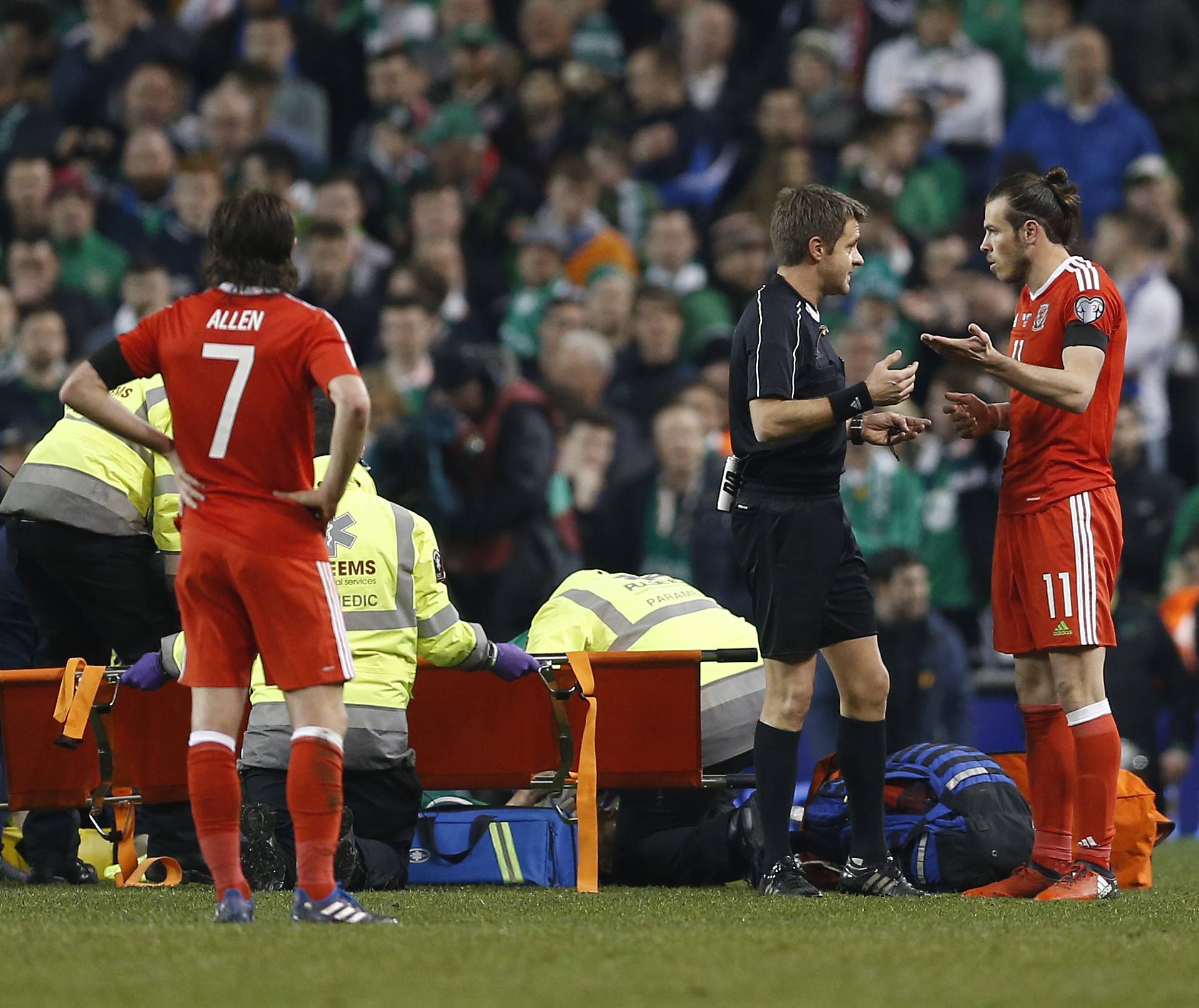 Republic of Ireland's Seamus Coleman receives medical attention as Wales' Gareth Bale speals to referee Nicola Rizzoli