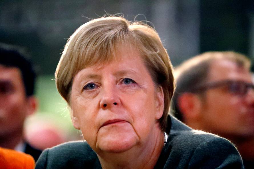 FILE PHOTO: German Chancellor Angela Merkel listens to Hesse State Prime Minister Volker Bouffier's speech during his election campaign rally in Ortenberg