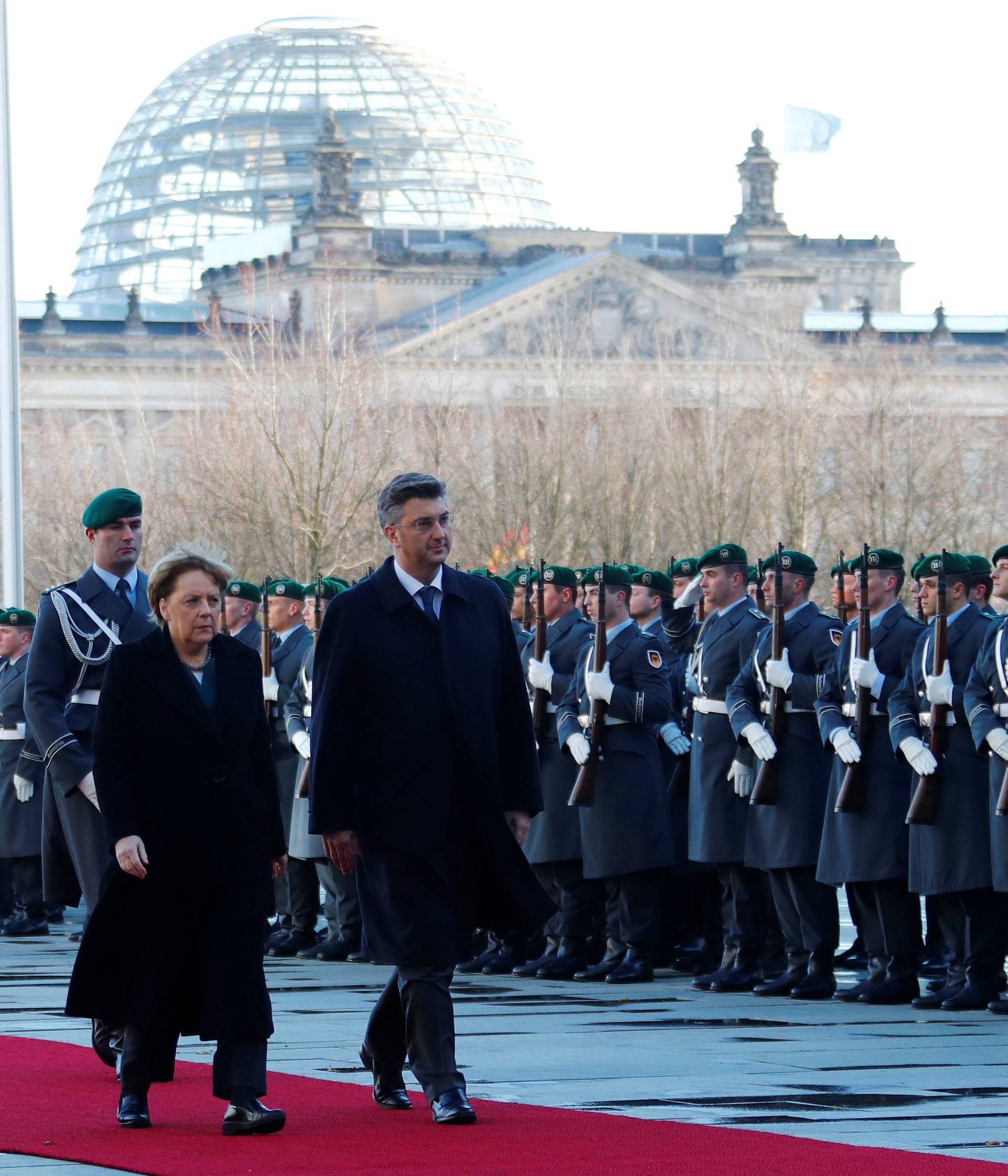 Croatia's Prime Minister Plenkovic and German Chancellor Merkel review the honor guard during a welcoming ceremony in Berlin