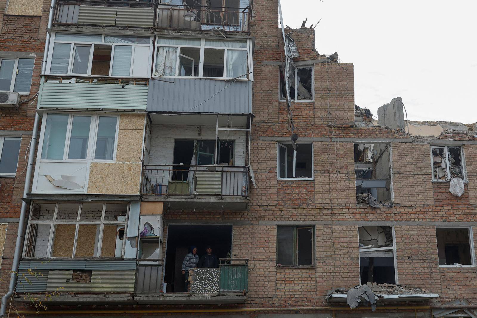 Local resident Tetiana Honcharova and her husband Mykhailo stand inside of their apartment damaged by a recent Russian missile attack in Mykolaiv