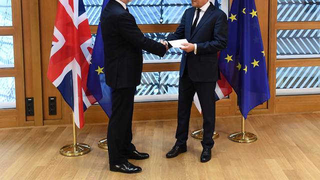 Britain's permanent representative to the European Union Tim Barrow hand delivers British Prime Minister Theresa May's Brexit letter in notice of the UK's intention to leave the bloc to EU Council President Donald Tusk in Brussels