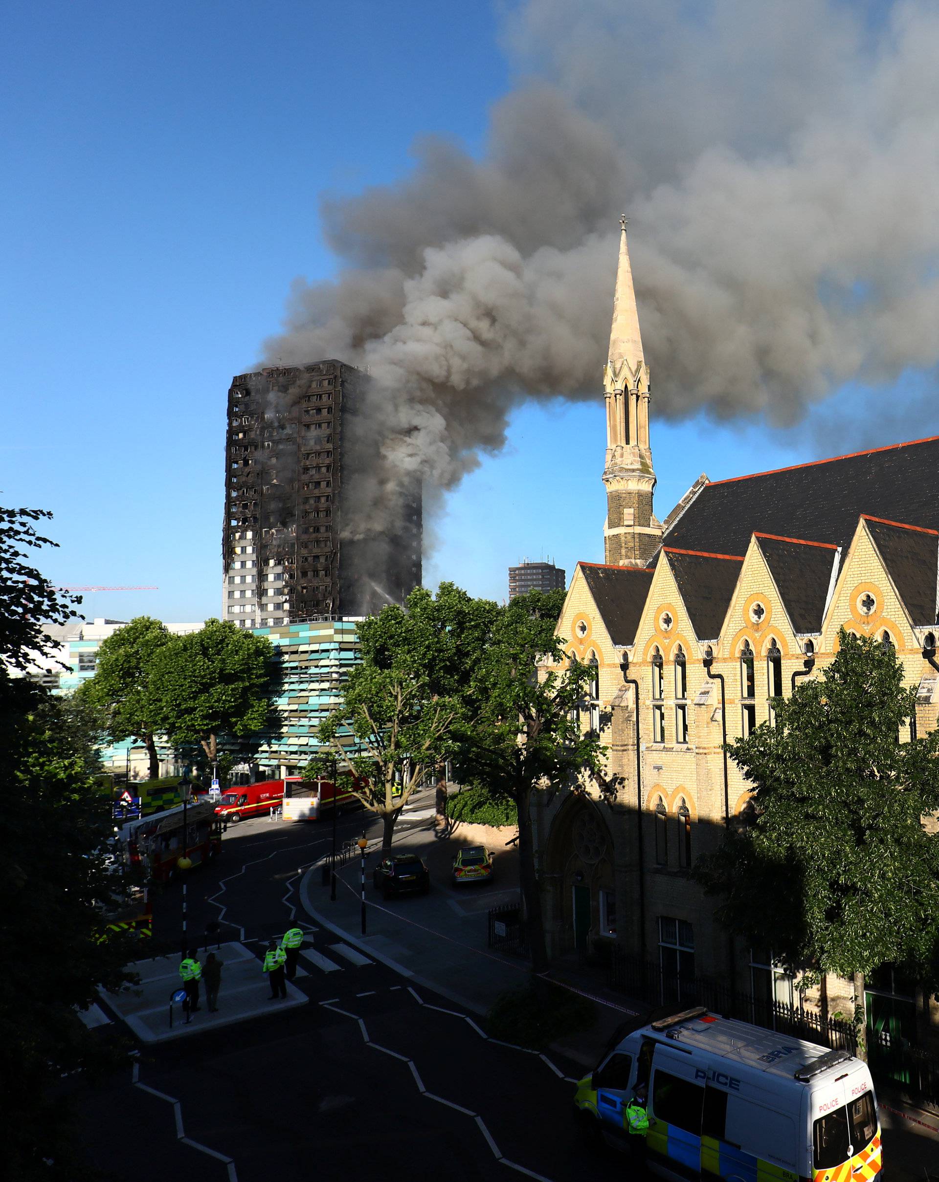 Police officers cordon off an area close to the scene of a serious fire in a tower block at Latimer Road in West London