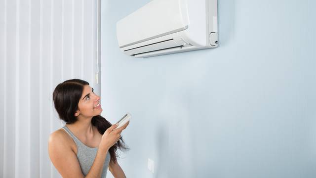 Woman Holding Remote Control Air Conditioner