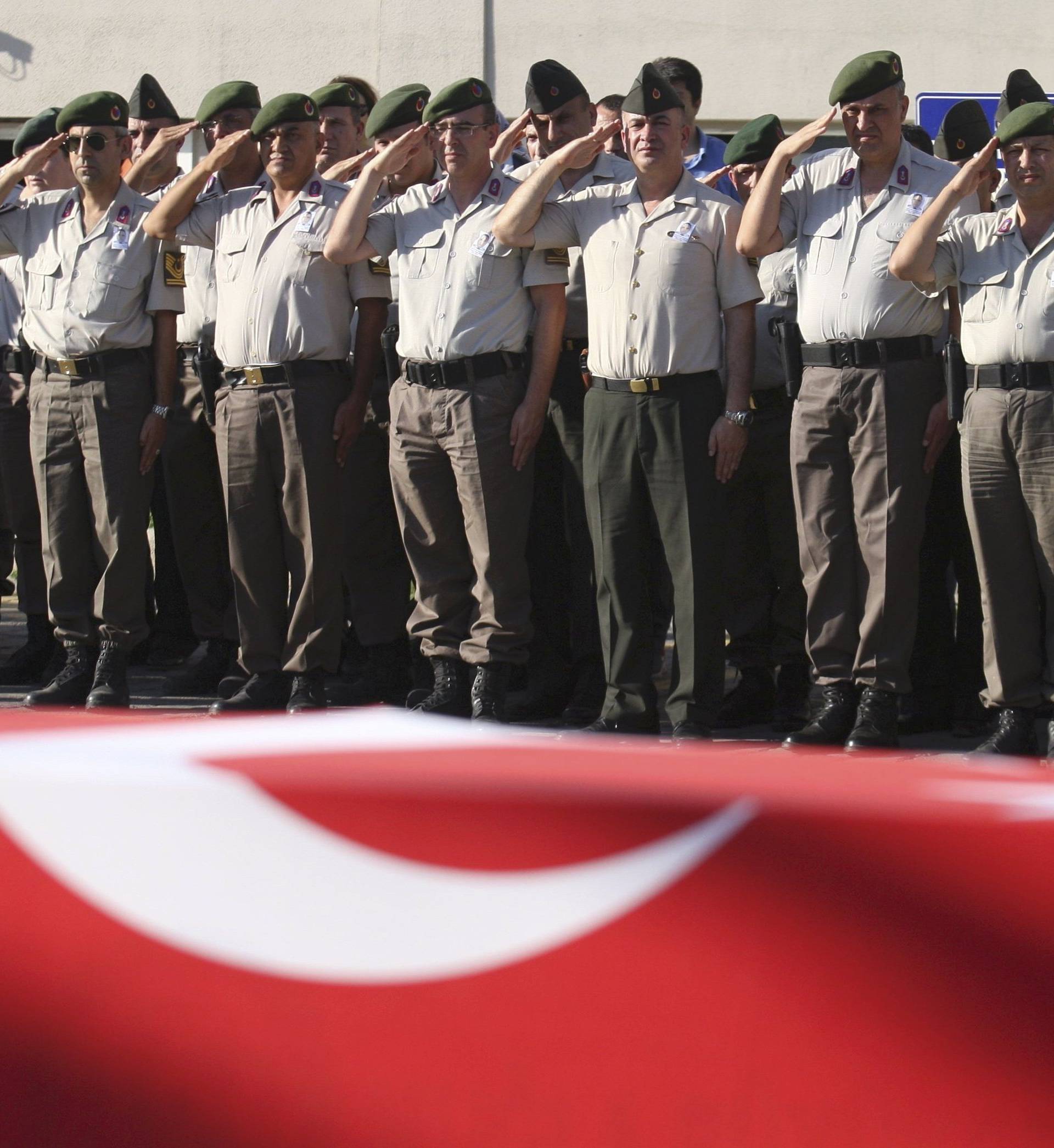Turkish police officers salute during a funeral ceremony for police officer Nedip Cengiz Eker in Marmaris