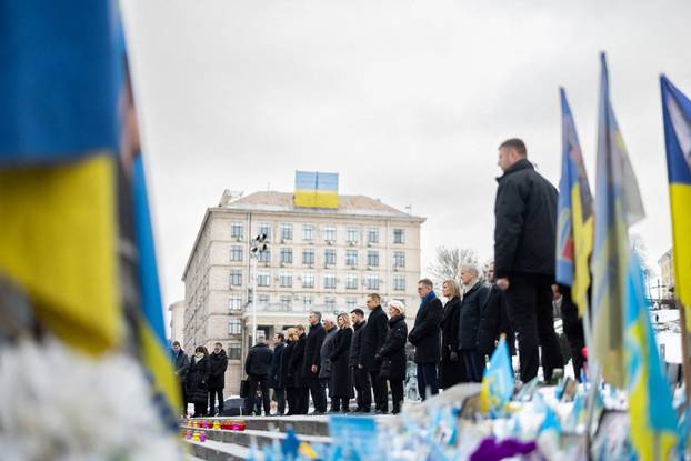 Ukraine's President Zelenskiy his wife Olena and foreign leader visit a makeshift memorial to fallen Ukrainian defenders at the Independent Square on the fourth anniversary of Russia's full-scale invasion, in Kyiv
