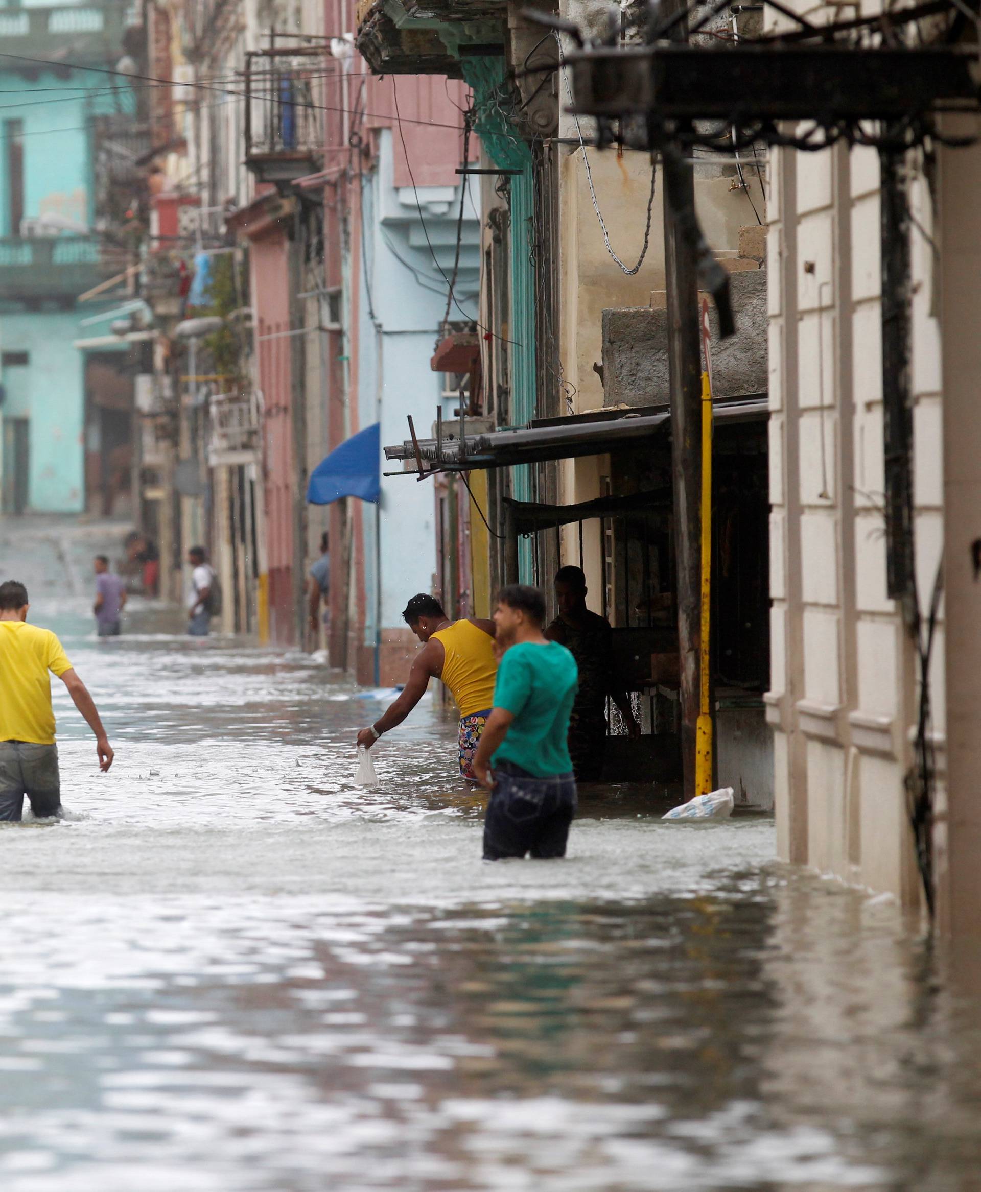 People wade through a flooded street after the passing of Hurricane Irma, in Havana