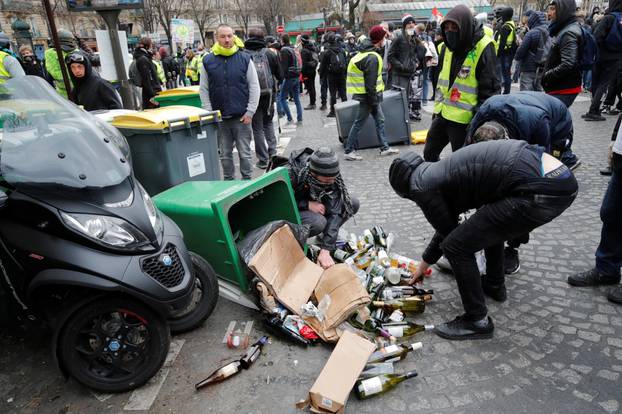 Protesters pick up bottles during a demonstration by the "yellow vests" movement in Paris