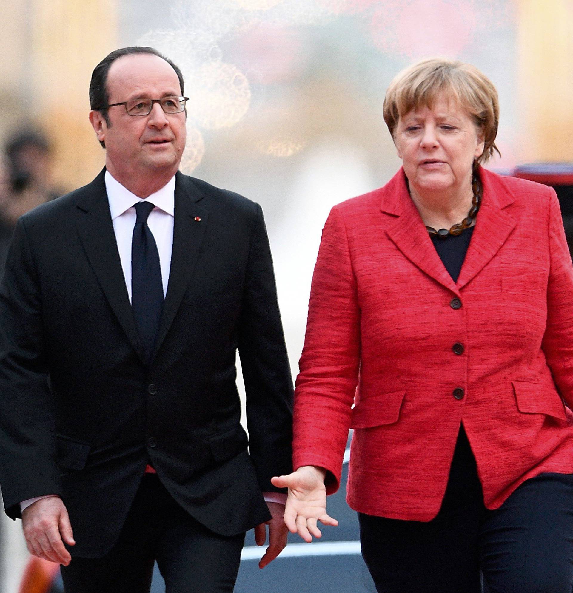 French President Francois Hollande welcomes German Chancellor Angela Merkel during arrivals for a Franco-German-Italian-Spanish summit ahead of the upcoming EU Summit in Versailles