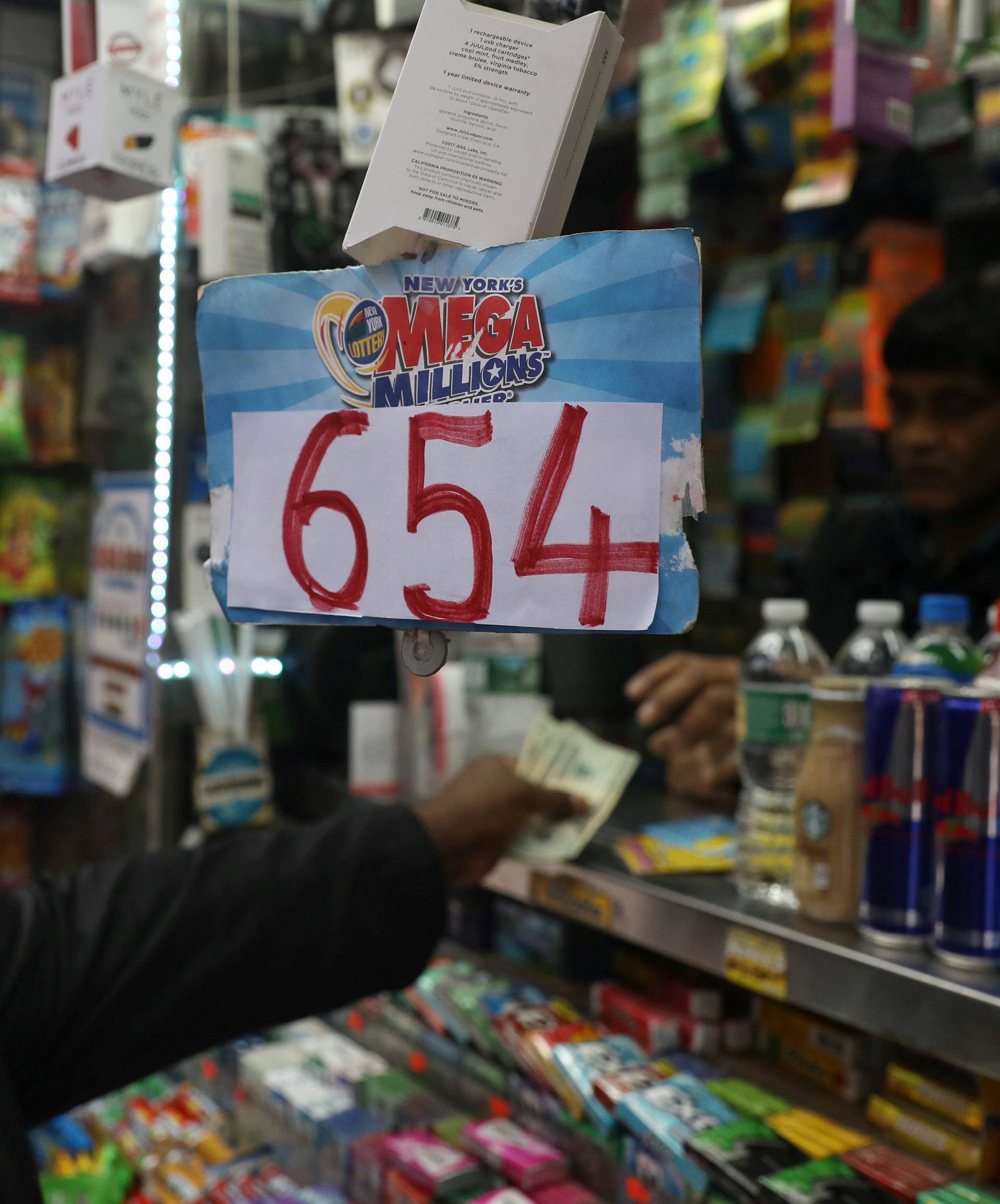A man buys Mega Millions lottery tickets for Tuesday's drawing after jackpot rose over $650 million in New York