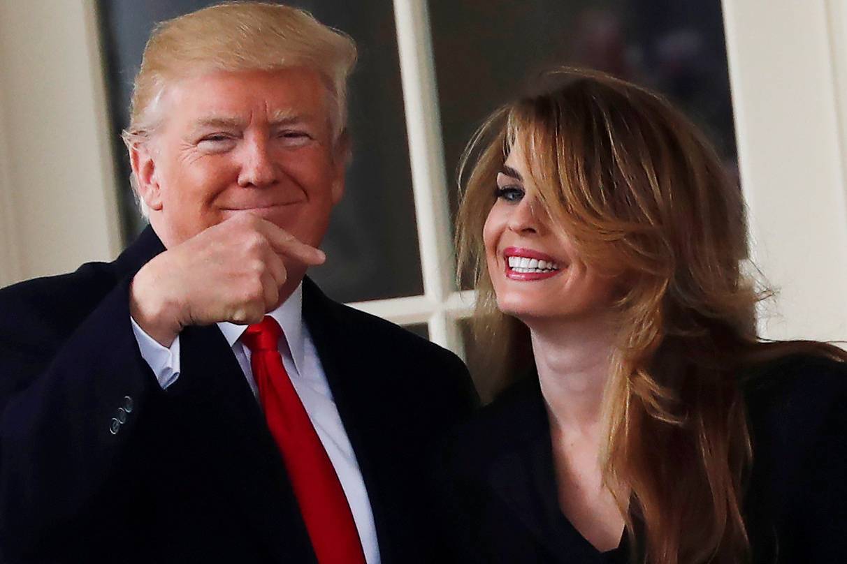 U.S. President Donald Trump reacts as he stands next to former White House Communications Director Hope Hicks outside of the Oval Office as he departs the White House for a trip to Cleveland, Ohio, in Washington D.C., U.S.