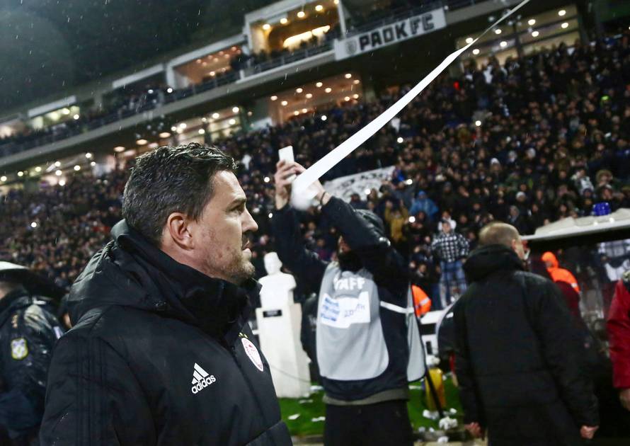 Olympiacos coach Oscar Garcia looks on as an object is hurled towards his face during a Greek Super League soccer match between PAOK and Olympiacos in Thessaloniki