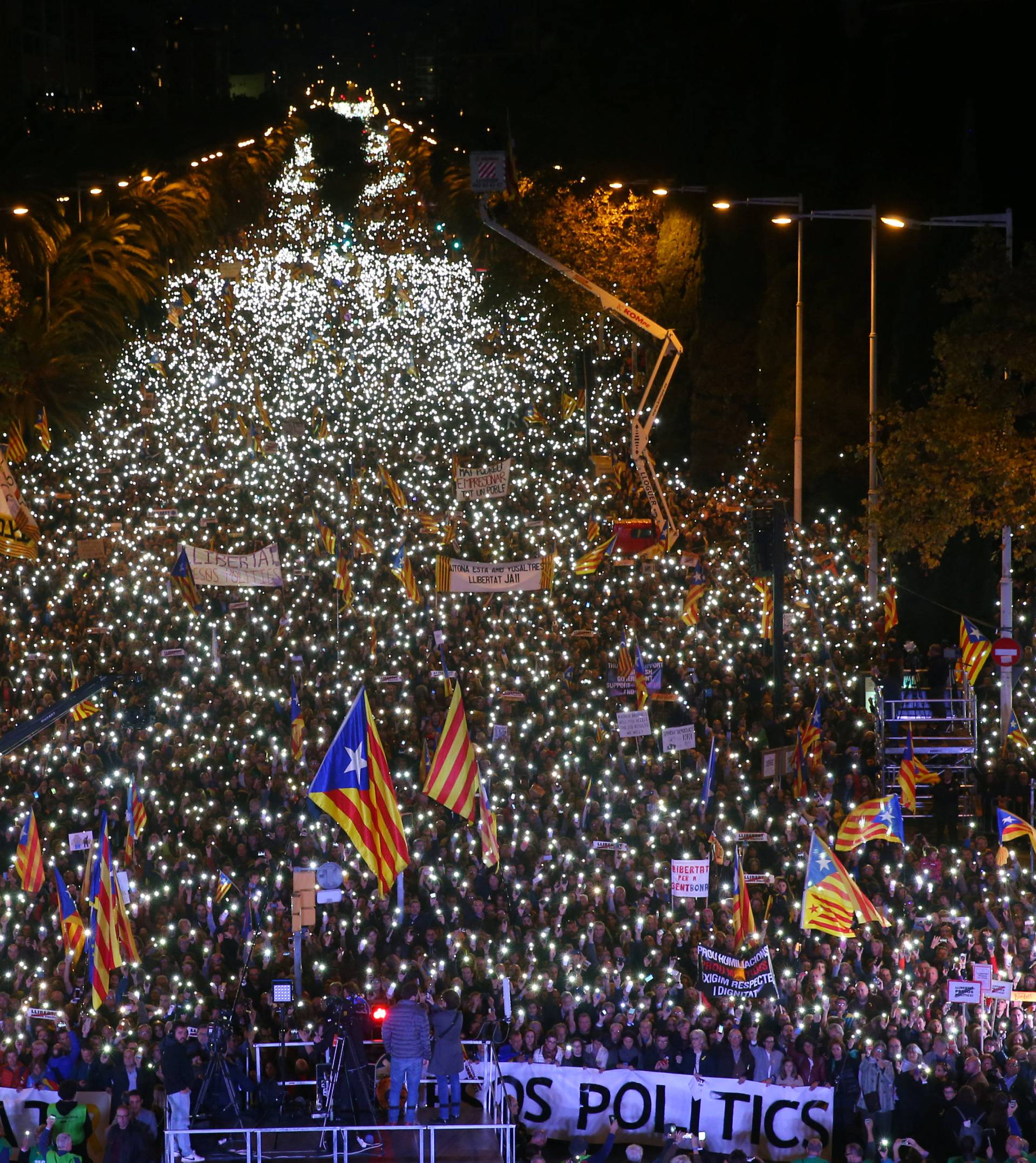 Protesters hold the lights of their mobile phones as they wave Estelada flags during a demonstration called by pro-independence associations asking for the release of jailed Catalan activists and leaders, in Barcelona